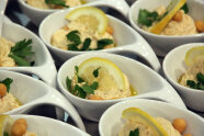 Bild mit Hummus von der Kichererbse in Schälchen serviert und dekoriert mit Zitronenscheiben