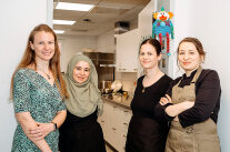 vier Mitarbeiterinnen der Kita Zugspitzstraße posieren fröhlich vor der kleinen Küche