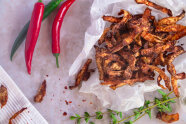 Geröstete Kartoffelschalen aus Bio-Kartoffeln mit Chilischoten daneben