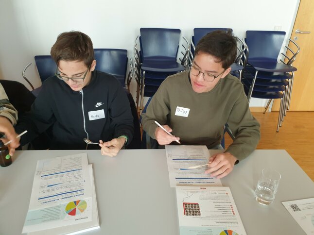 zwei Jungen sitzen am Tisch und füllen einen Fragebogen zur Sensorik aus