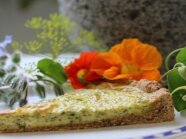 Ein Stück Quiche garniert mit Kapuzinerkresse