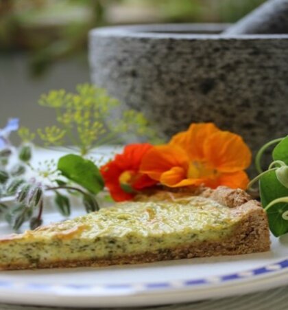 Ein Stück Quiche garniert mit Kapuzinerkresse