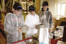 Drei Schüler experimentieren mit Mehl und Korn