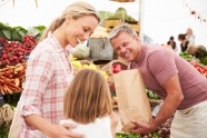 Familie kauft auf einem Markt ein.