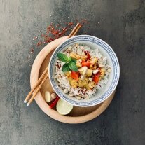 Gemüse-Curry mit Reis, dekoriert mit Stäbchen, Limette und Chili