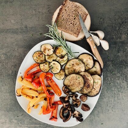 Teller mit bunten Antipasti und einer Scheibe Brot