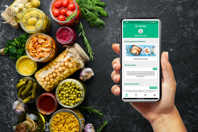 Smartphone in der Hand neben Einmachgläsern, auf welchem die stocky App abgebildet ist