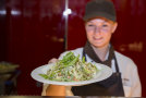Kantinenangestellte präsentiert einen Salatteller