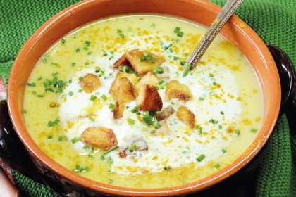 Ingwer-Curry Suppe mit Kartoffelwürfeln in einer Tonschale angerichtet